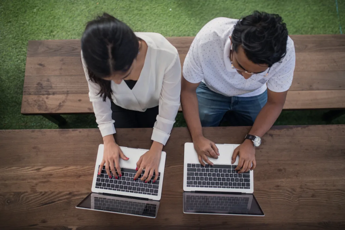 Two developers pairing on laptops